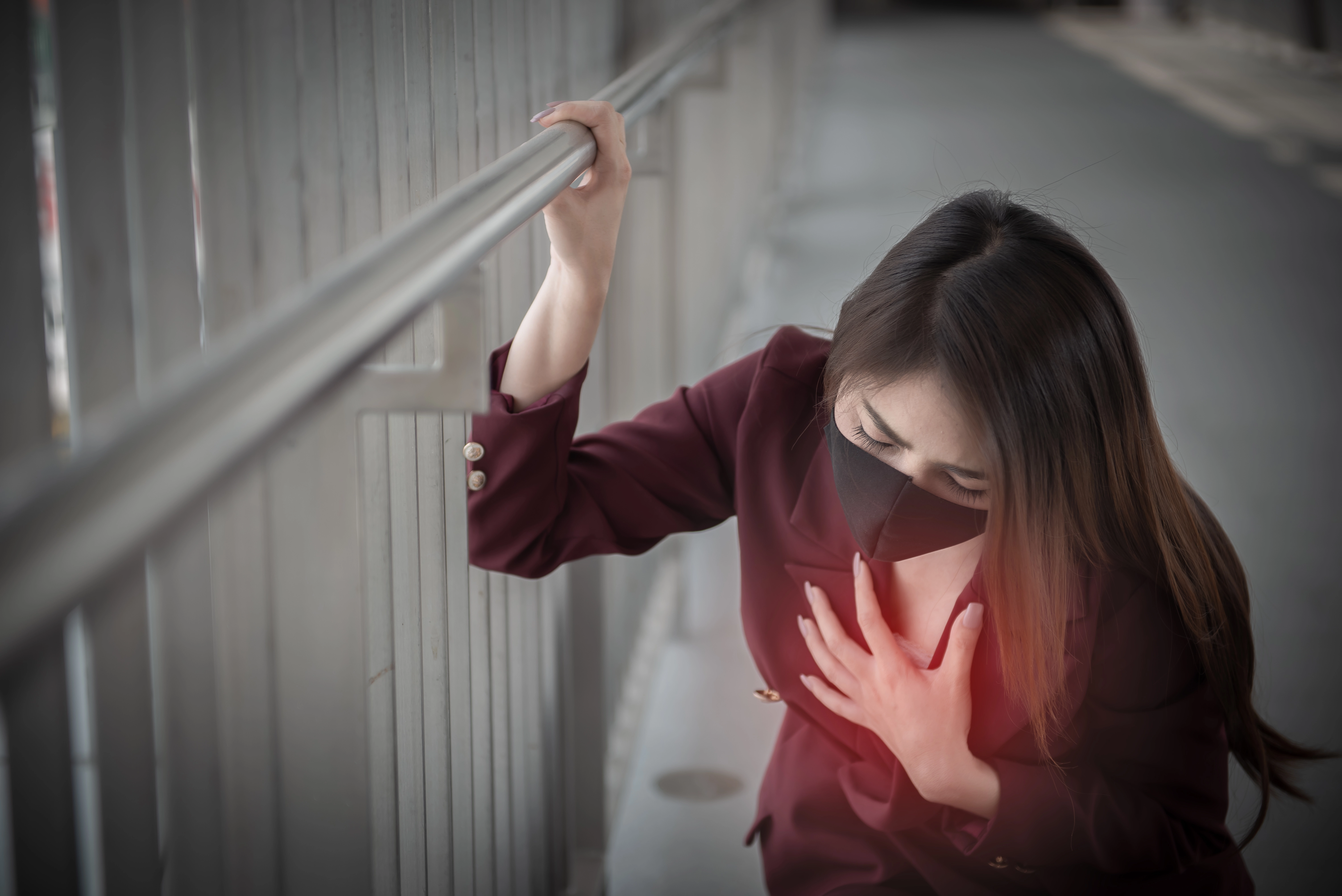 女子胸悶氣短、手捂胸口，示意心律不整與氣血不足的臨床症狀。